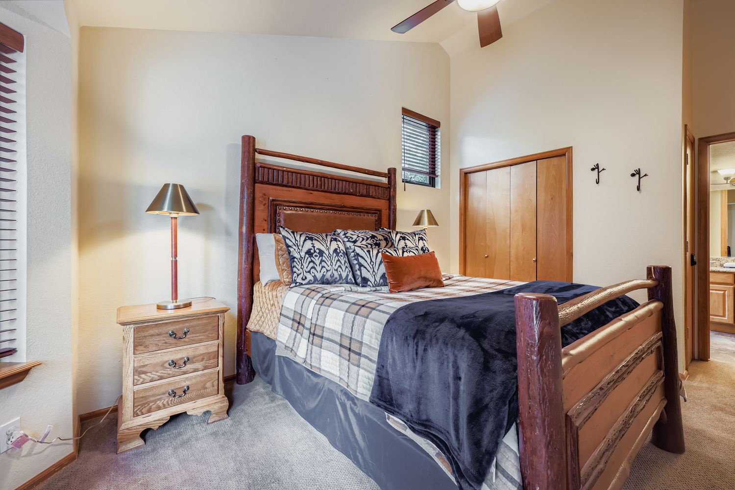 Sink into your comfortable wooden bed with plaid linens and rustic charm, complete with warm bedside lighting.