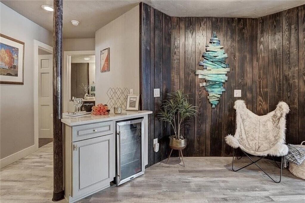 Settle into your cozy retreat with rustic wood walls, modern kitchenette, and plush seating perfect for unwinding.