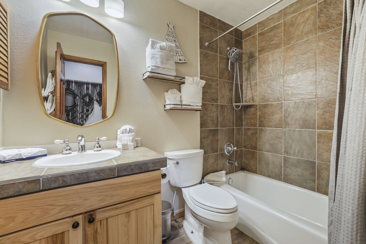 Step into this inviting bathroom where rich earth tones create a warm retreat. Enjoy your private tub-shower combo with sleek tile accents and fresh linens waiting for you.