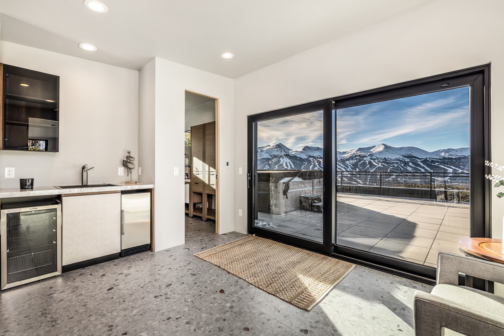Step into your modern kitchen where sleek appliances meet stunning mountain views through floor-to-ceiling windows.