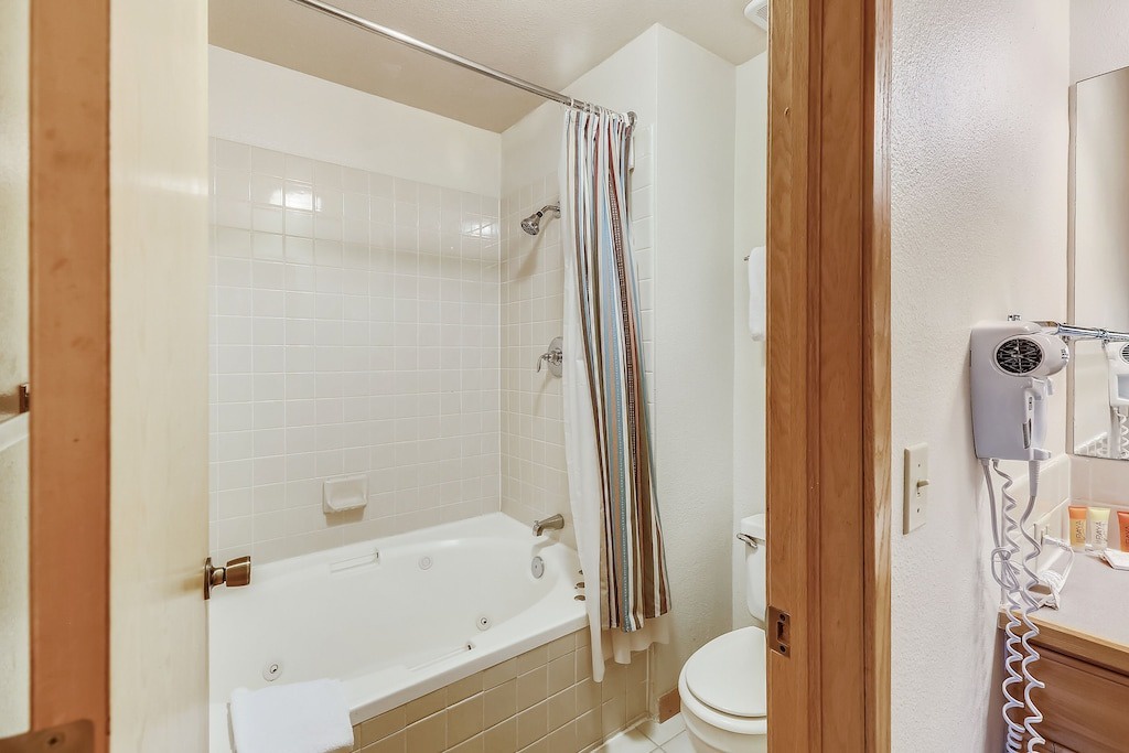 Step into your private bathroom with a relaxing jetted tub and shower combo, complete with fresh towels and a hair dryer for your convenience.