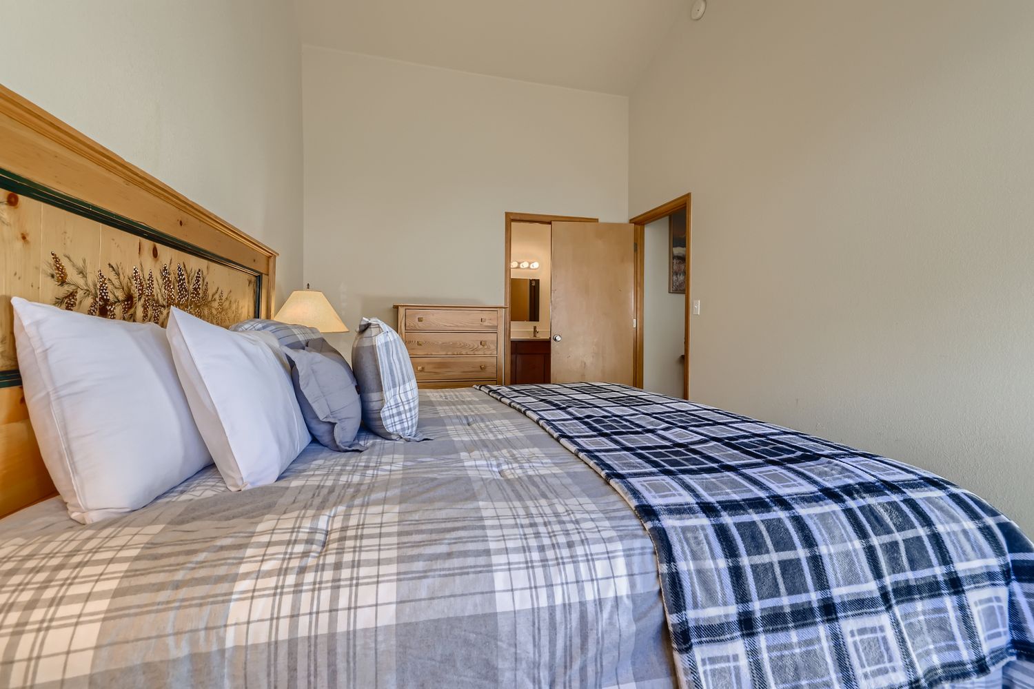 Drift off in this cozy bedroom featuring rustic wheat décor and soft plaid bedding that wraps you in comfort.