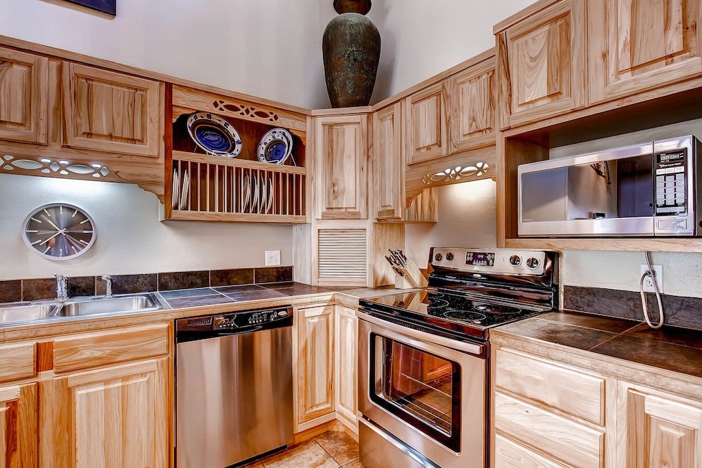 Whip up your favorite meals in this fully equipped kitchen featuring warm wood cabinetry, stainless steel appliances, and thoughtful storage solutions.