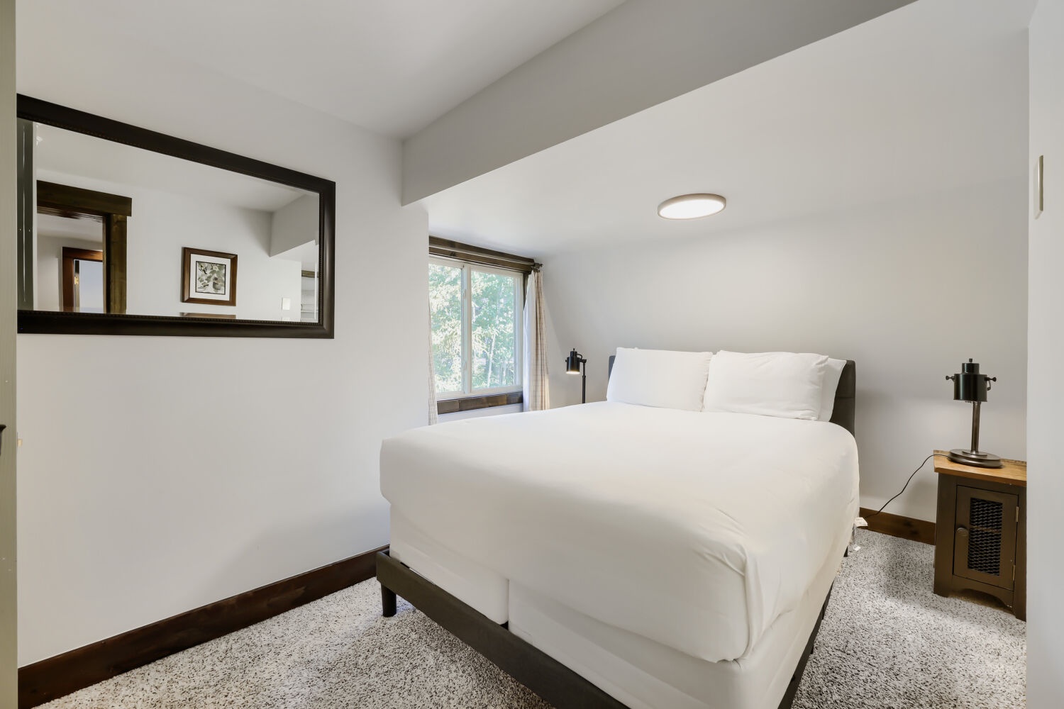 Slip into crisp white linens and wake to soft natural light filtering through the window. Your peaceful retreat awaits with modern touches and a serene atmosphere for restful nights.