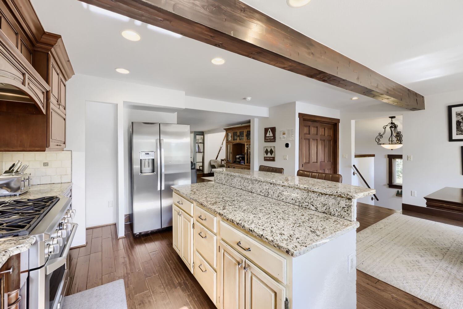 Step into your gourmet kitchen where rustic wood beams meet modern elegance. Cook and gather around the spacious granite island while natural light fills every corner of your inviting retreat.