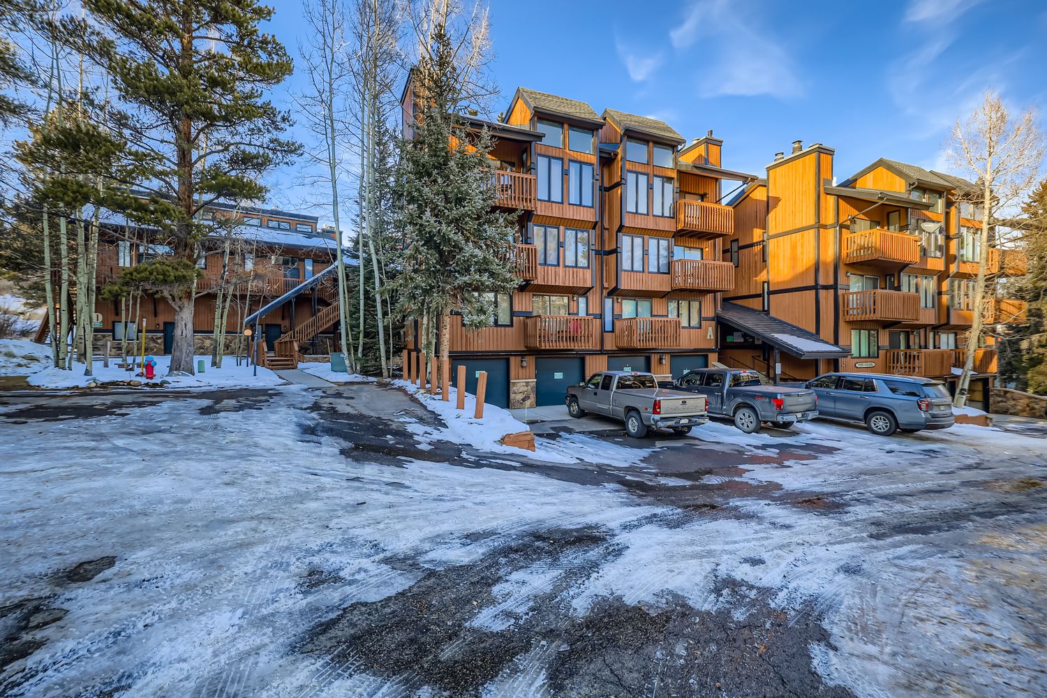Mountain resort building with convenient parking and winter charm surrounded by snow-covered grounds.