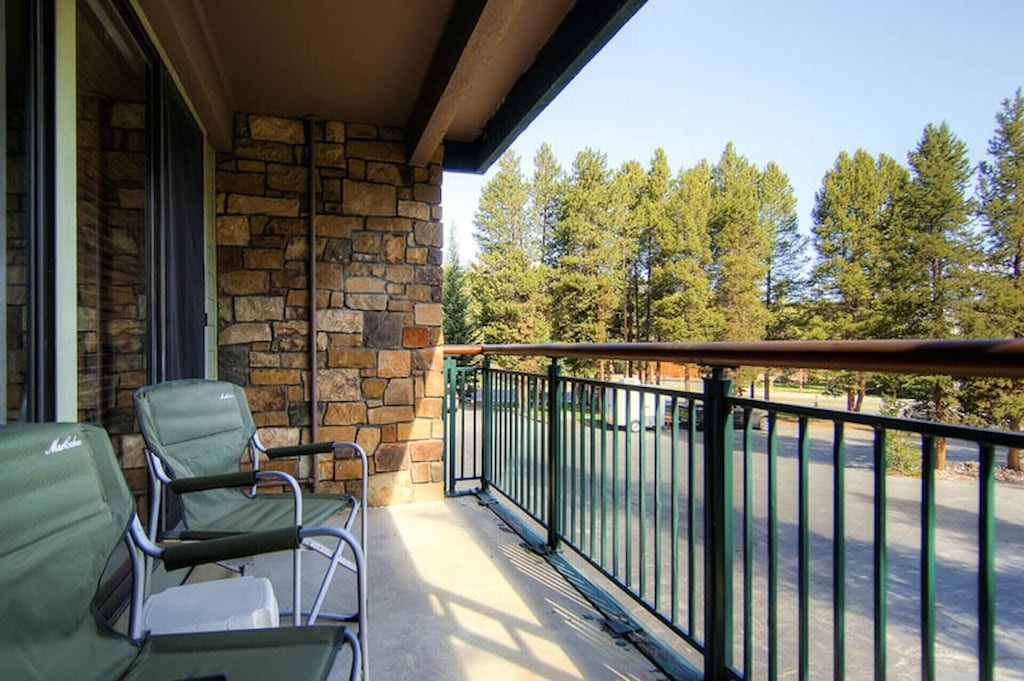 Unwind on your private balcony with comfortable seating, surrounded by towering trees and peaceful forest views.