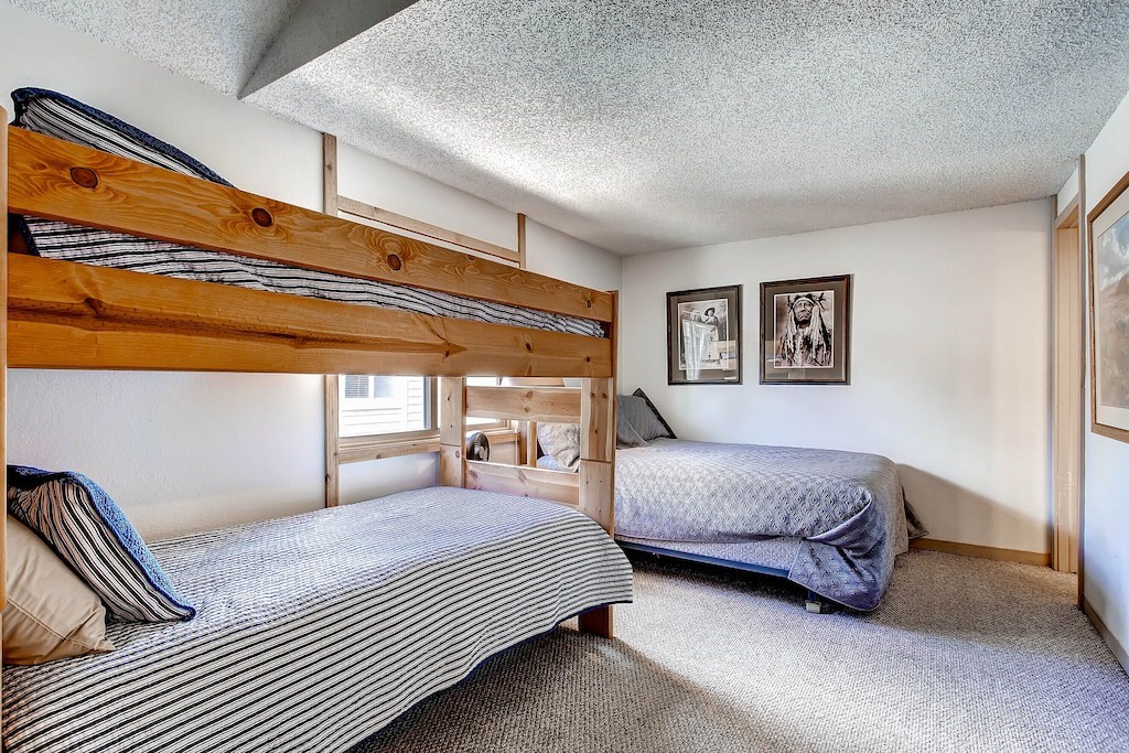 Cozy bedroom with stylish bunk beds and separate bed - perfect for families or groups sharing comfortable space together.