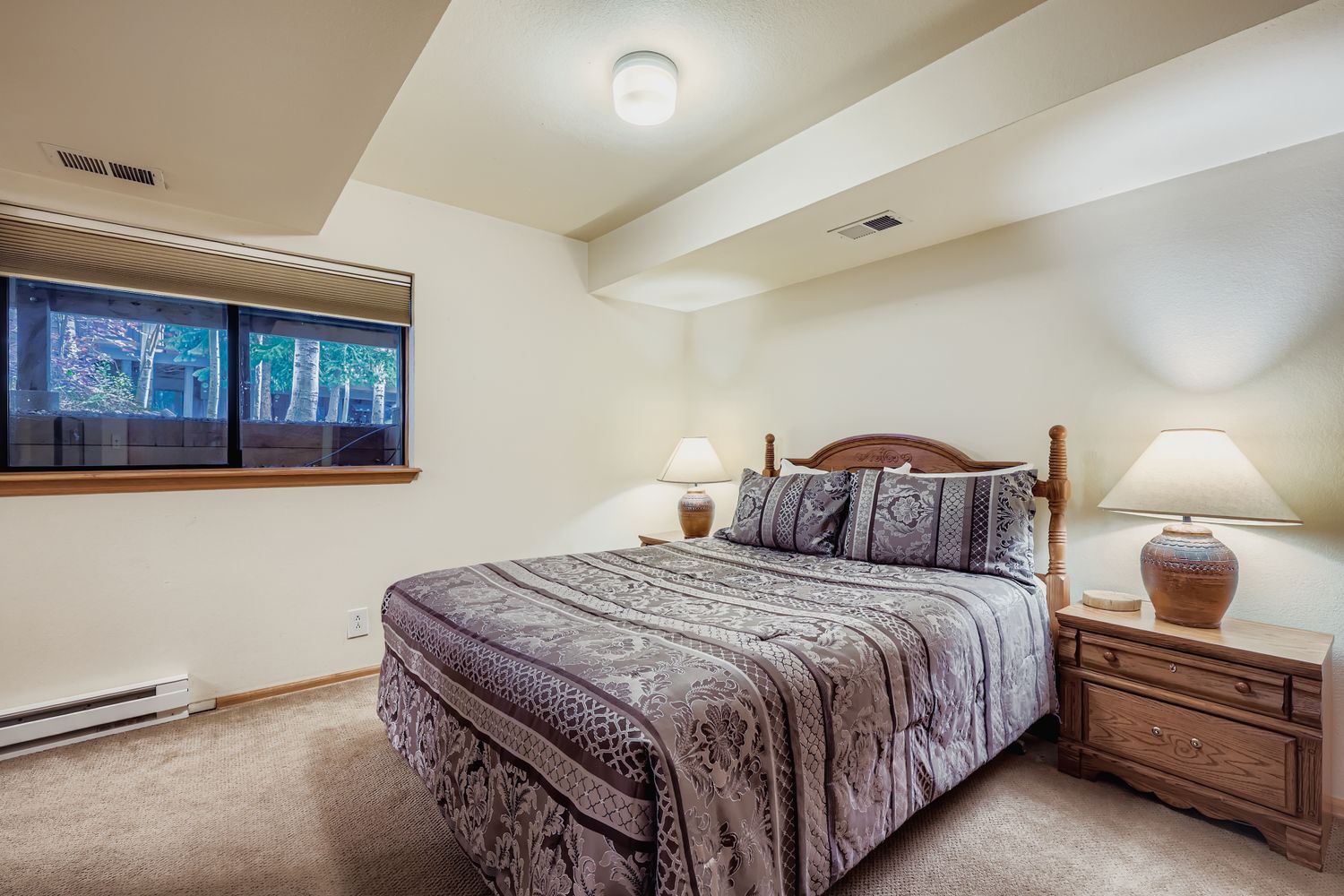 Sink into your cozy retreat with warm wood furnishings and soft lighting that creates the perfect atmosphere for peaceful nights.