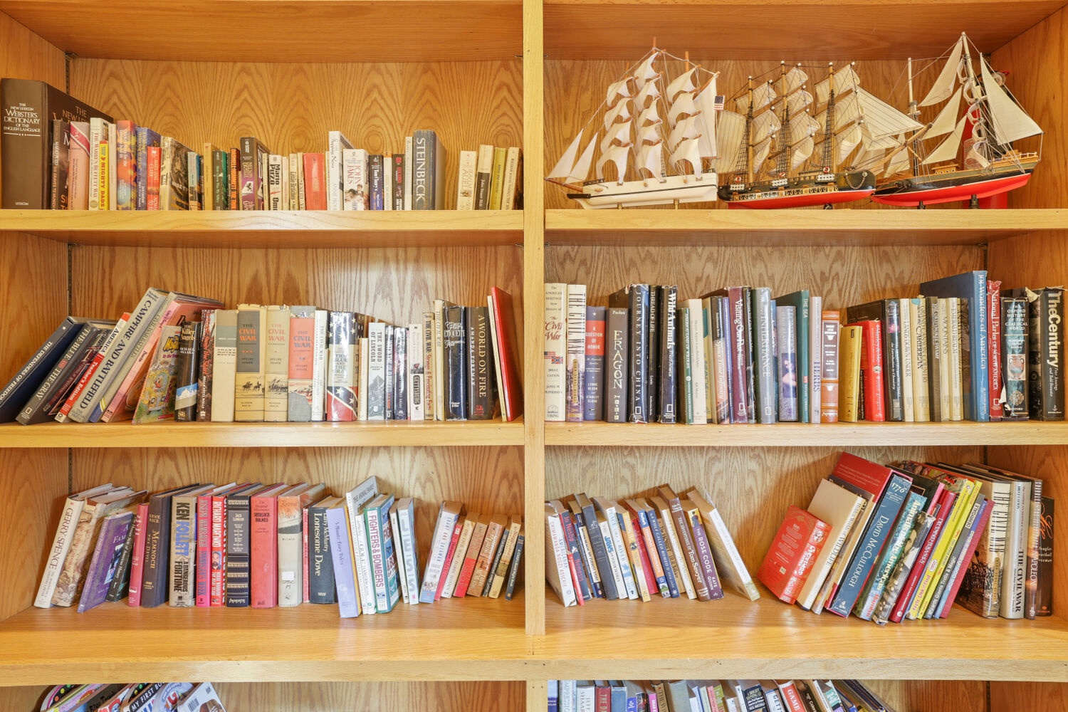 Curl up with a good book from your personal library, featuring maritime charm with model ships that add character to your peaceful reading nook.