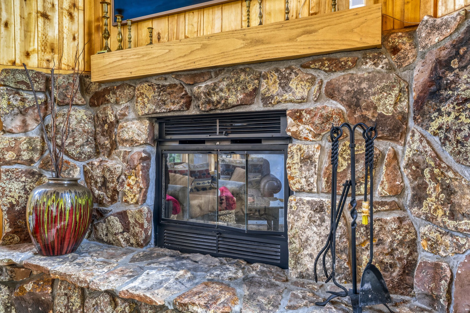 Gather around this stunning stone fireplace with its rustic charm and decorative touches—perfect for cozy evenings in your mountain retreat.