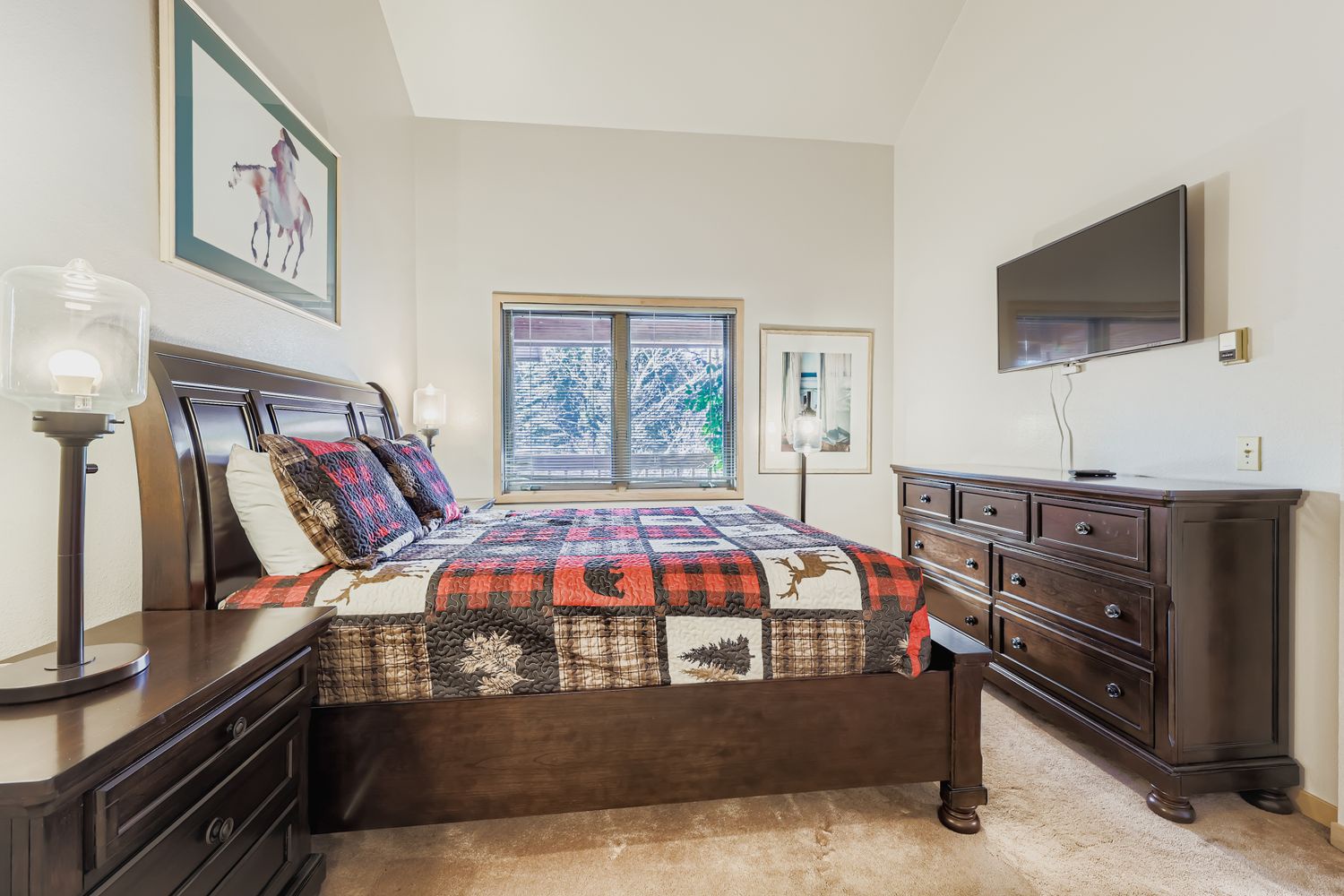 Sink into this cozy bedroom featuring rich wooden furniture and rustic quilted bedding that promises restful nights after mountain adventures.