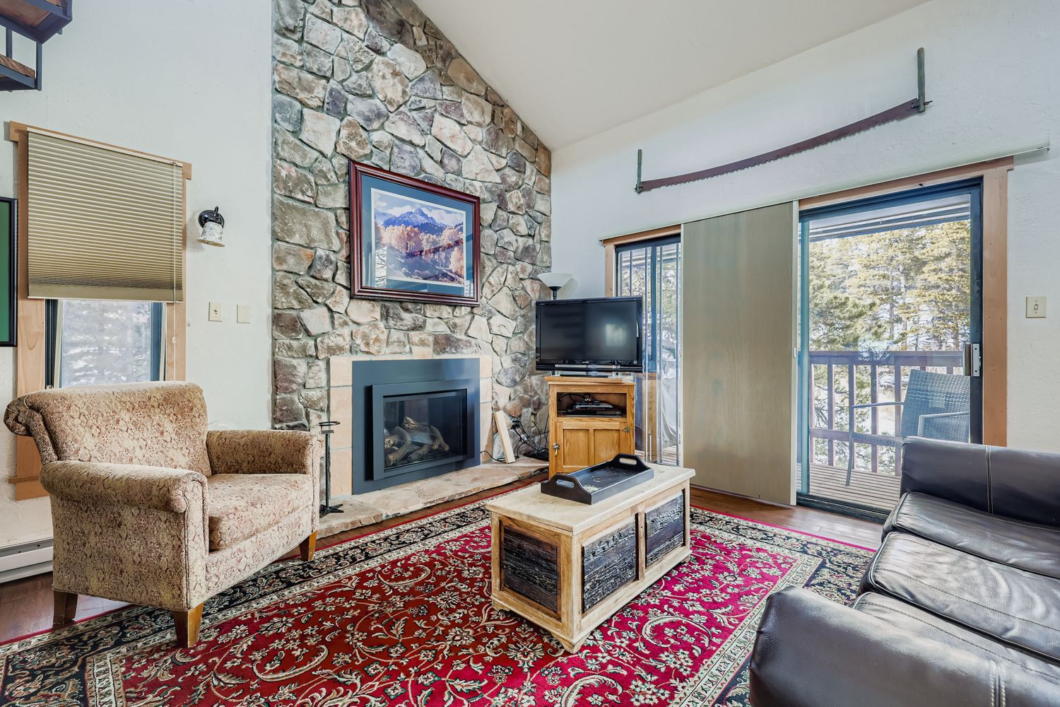Cozy up by the stone fireplace in this mountain retreat with leather seating and forest views through your private balcony.