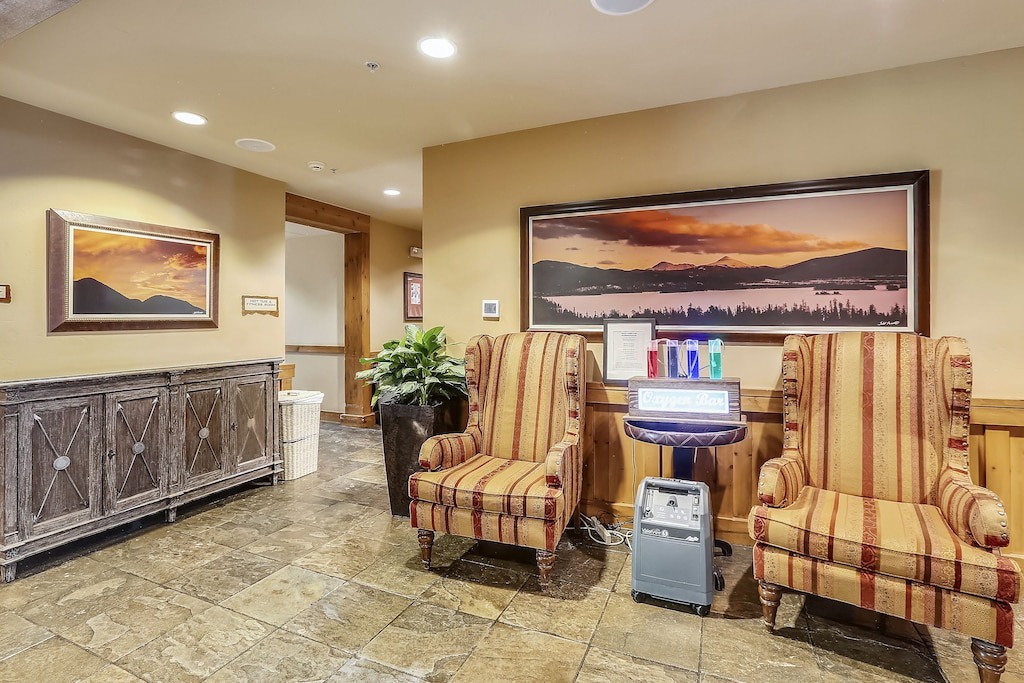 Relax in comfortable striped armchairs while enjoying mountain landscape artwork and convenient refreshment stations in this welcoming lobby space.