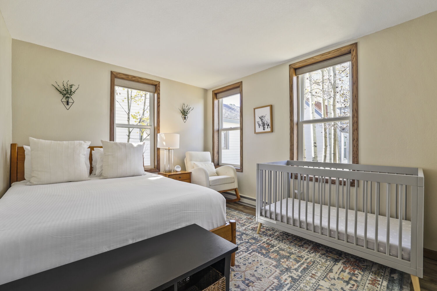Your cozy bedroom awaits with a plush bed, soft seating for relaxation, and a crib ready for your little one. Natural light fills the space, making it warm and welcoming.