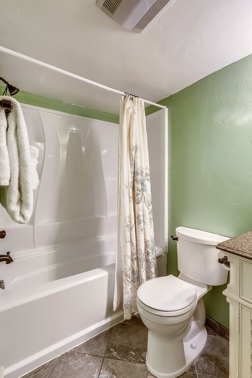 Your private bathroom offers everything you need with soothing green walls, fresh towels, and a spacious tub-shower combo for unwinding after your adventures.