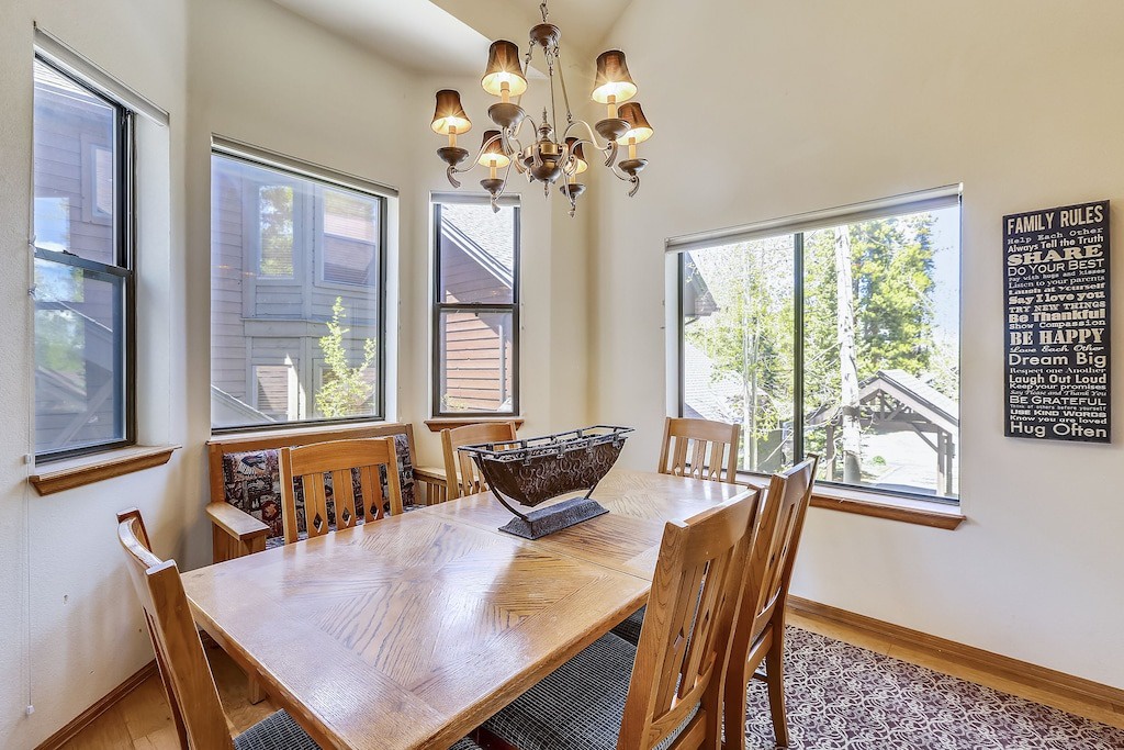 Gather around this beautiful dining table where memorable meals come together under warm chandelier light.