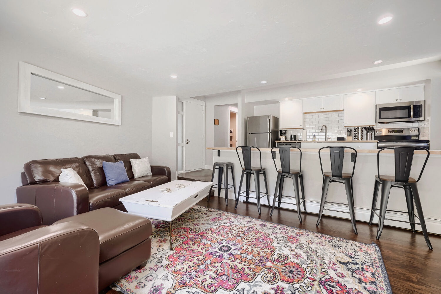 Picture yourself here: spacious open living with a comfy leather sofa, stylish bar seating, and a fully equipped kitchen where you can cook, gather, and unwind in your home away from home.