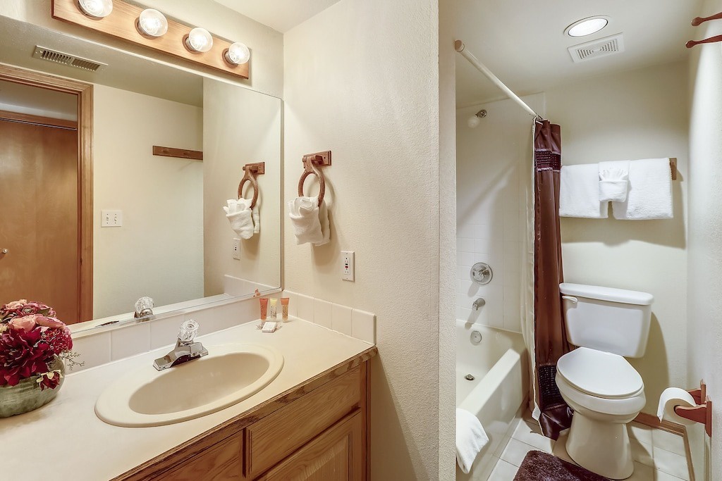 Your private bathroom features a vanity with Hollywood-style lighting, fresh towels, and a tub-shower combo for ultimate relaxation.