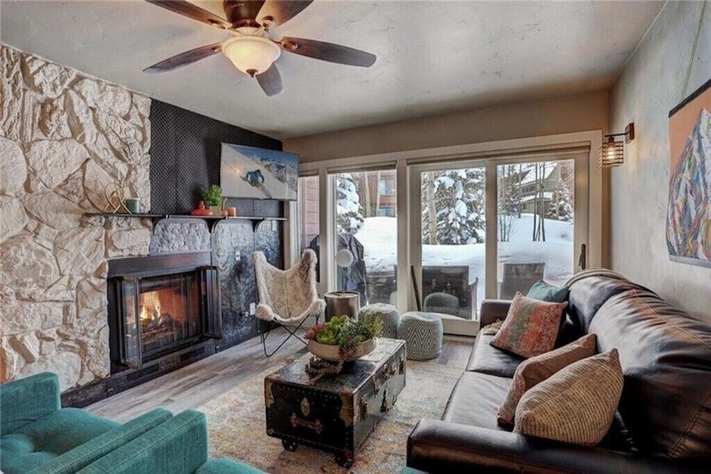 Curl up by your crackling stone fireplace while snow-covered trees create a magical winter backdrop outside your cozy mountain retreat.