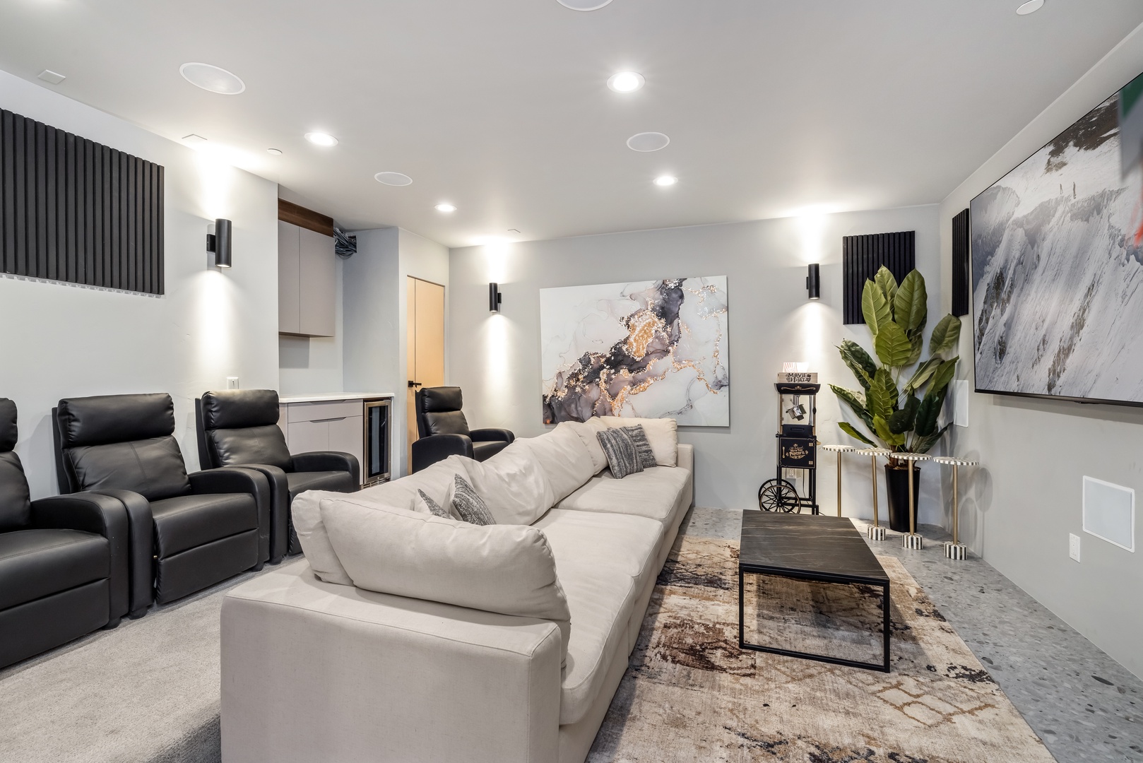 Sink into plush seating for movie nights in your private theater room with elegant artwork and ambient lighting.