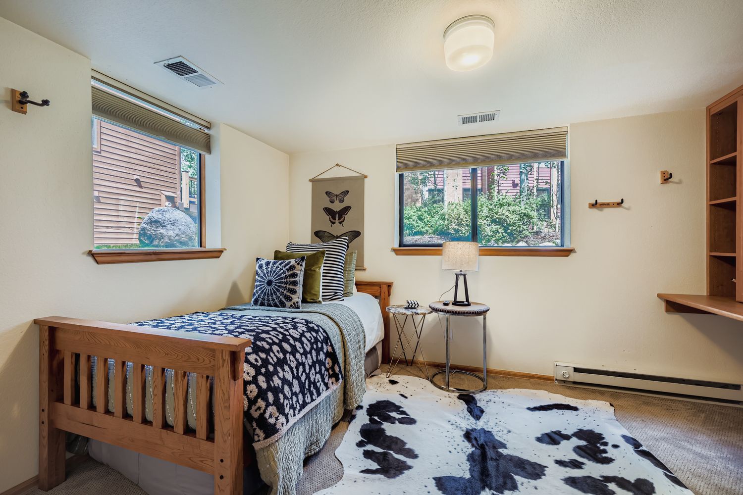 Rest easy in your cozy bedroom with natural light streaming through bamboo blinds and charming décor creating a peaceful retreat.