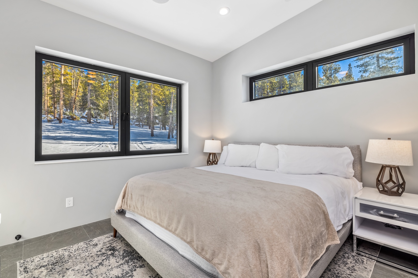 Wake up to breathtaking winter forest views from your cozy king bed, surrounded by modern comfort and serene mountain tranquility.