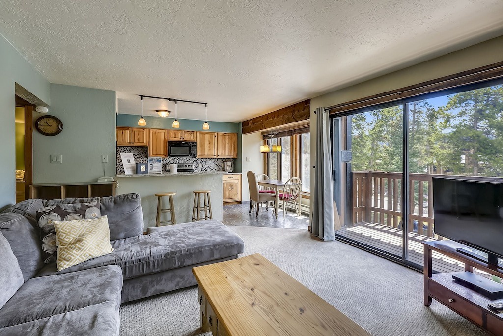 Sink into the plush gray sectional and enjoy your open-concept retreat, where kitchen, dining, and living flow seamlessly to your private balcony.