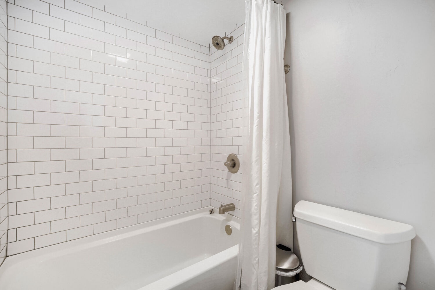 Refresh after your adventures in this clean, modern bathroom featuring a tub-shower combo with subway tile surround—your private retreat for unwinding.