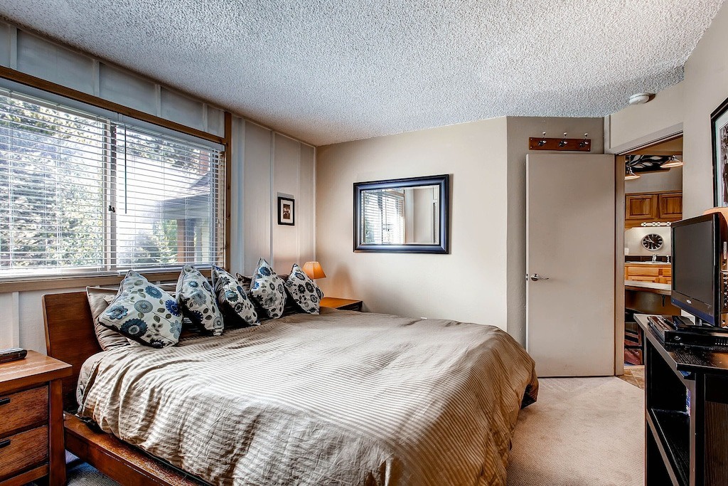 Sink into your comfortable bed with plush pillows while natural light filters through the window blinds.