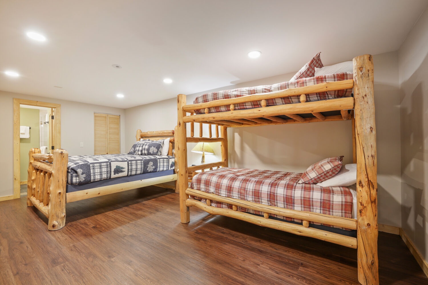 Rustic charm meets cozy comfort in this spacious bedroom equipped with oxygen regulation, handcrafted log bunk beds and warm hardwood floors—perfect for gathering your group after a day of adventure.