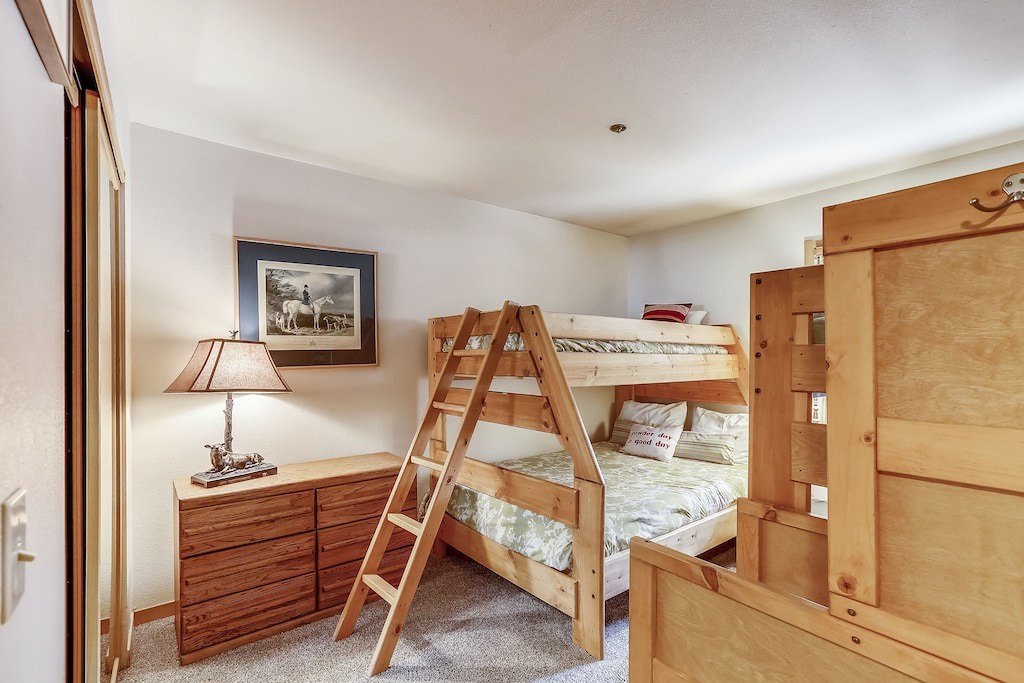 Your kids will love this cozy bunk bed retreat with warm wood furnishings and thoughtful touches for restful nights.