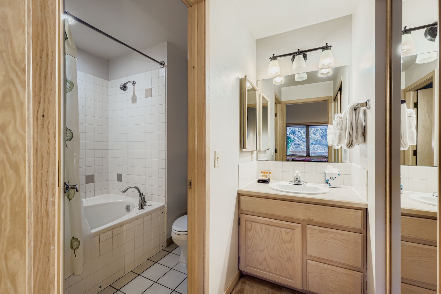Spacious bathroom with bathtub, shower, and dual mirrors offers everything you need to refresh after your mountain adventures.