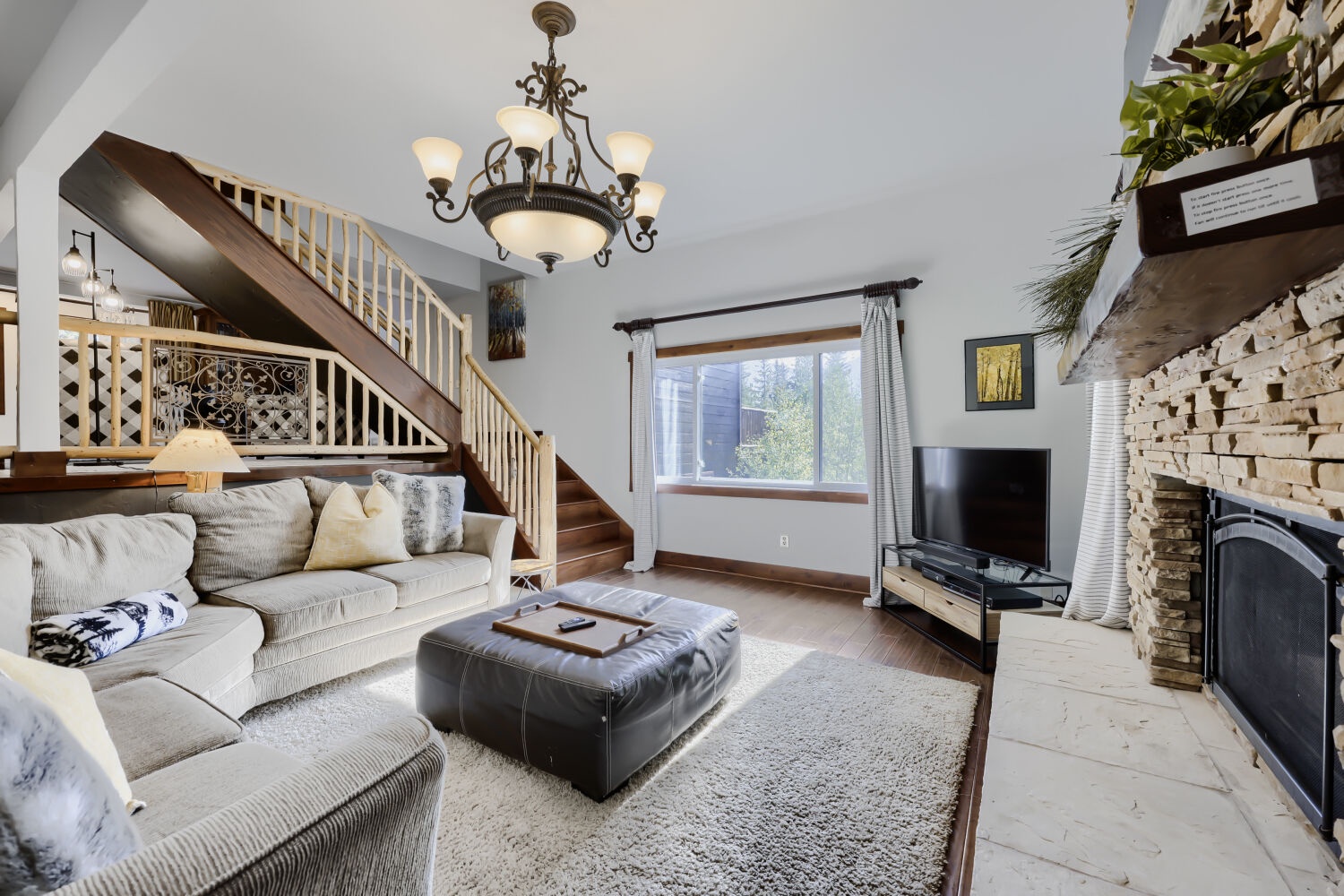 Unwind in your spacious living room with soaring ceilings, plush seating, and a beautiful stone fireplace. Natural light streams in while you relax by the fire or gather for movie nights.