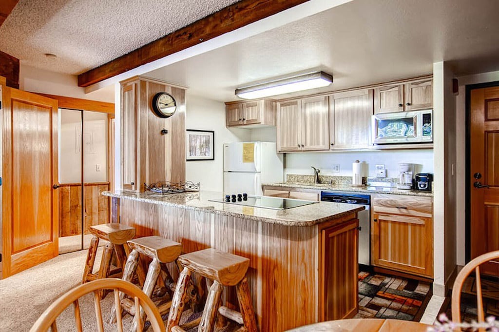 Gather around your spacious granite-topped island where rustic wood meets modern convenience in this fully-equipped mountain kitchen.