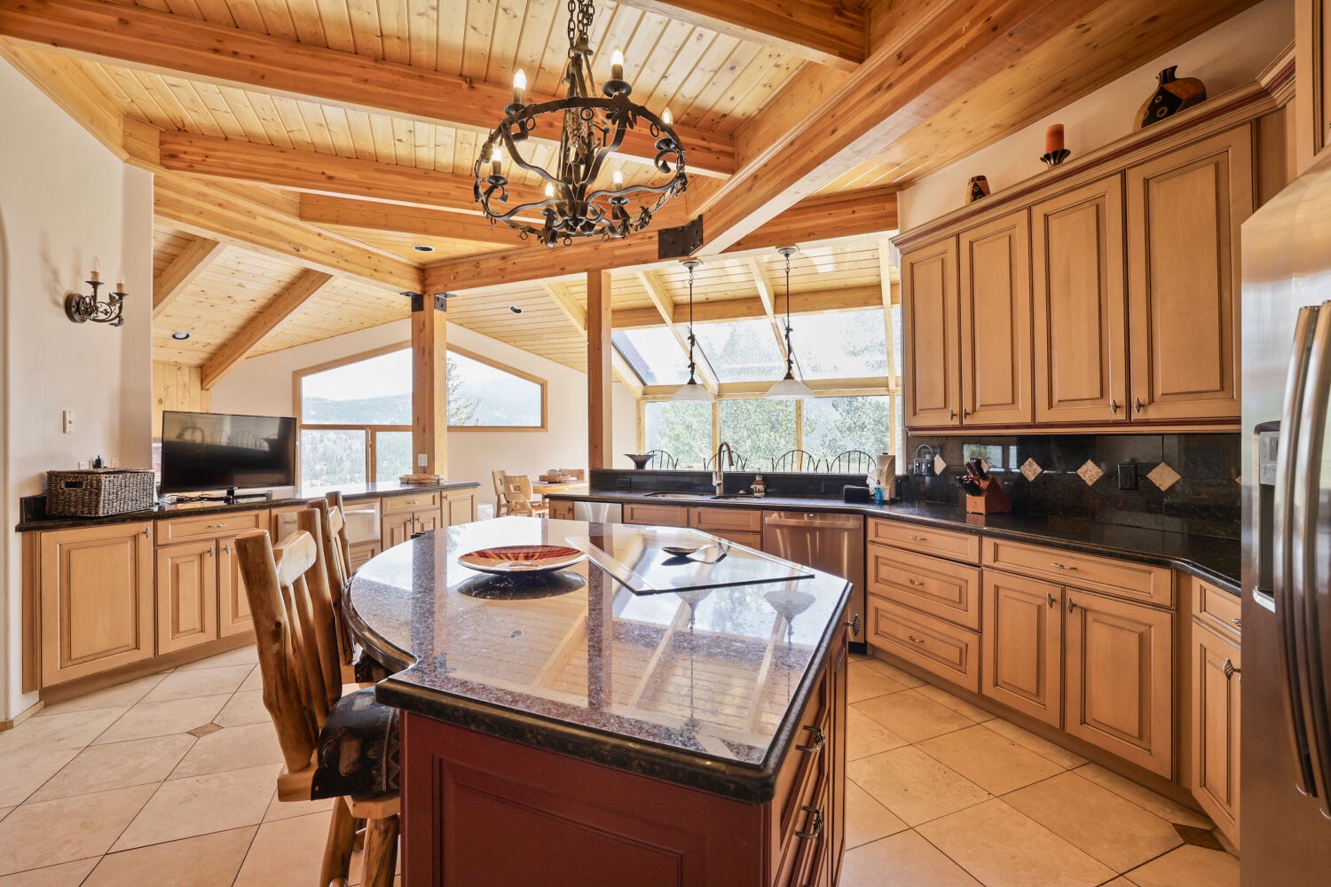 Step into this stunning great room where rustic wood beams and soaring ceilings meet chef-ready appliances. Your gourmet kitchen flows effortlessly into the dining and living spaces—perfect for gathering everyone together after a day of adventure.