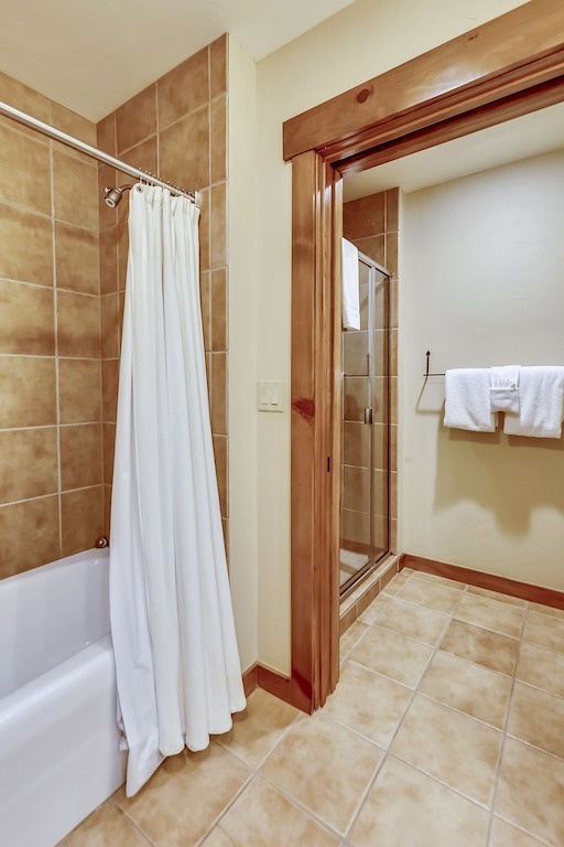 Your spacious bathroom features warm tiles, a relaxing tub with shower, and plenty of fresh towels for your comfort.