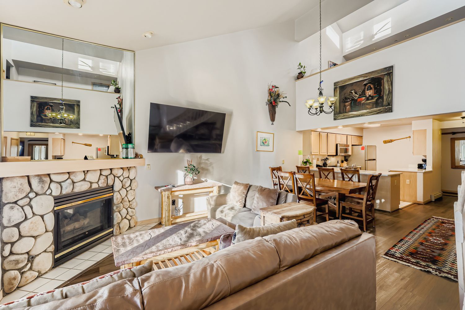 Gather in your spacious open living area with stone fireplace warmth, where comfort meets mountain charm for unforgettable vacation moments.