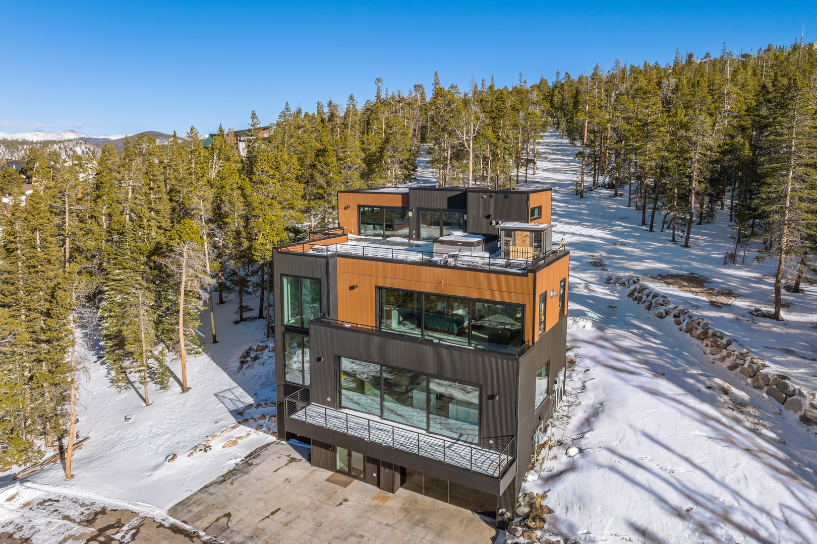 Modern mountain retreat nestled among snow-covered pines with stunning alpine views and ski slope access nearby.