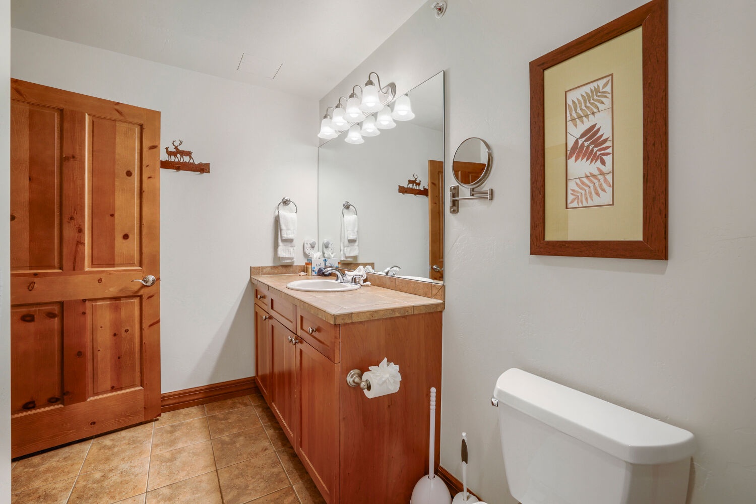 Step into your bright, spotless bathroom with plenty of counter space, fresh towels, and warm wood details that make you feel right at home.