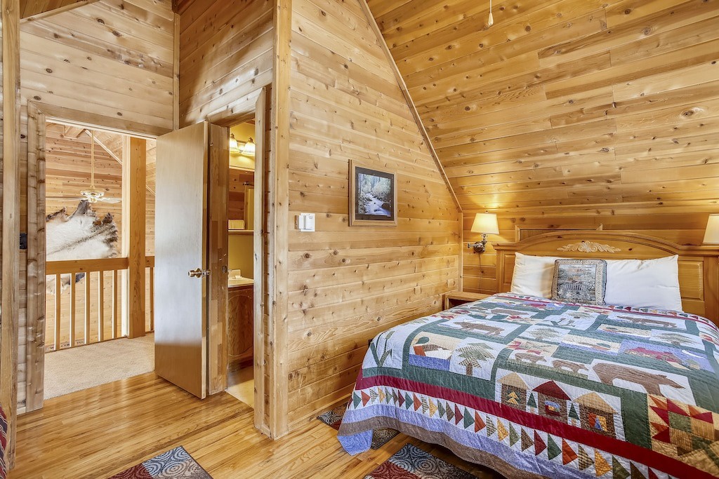 Cozy up in this charming log cabin loft bedroom with rustic wood walls, handmade quilts, and warm lighting creating your perfect mountain retreat.