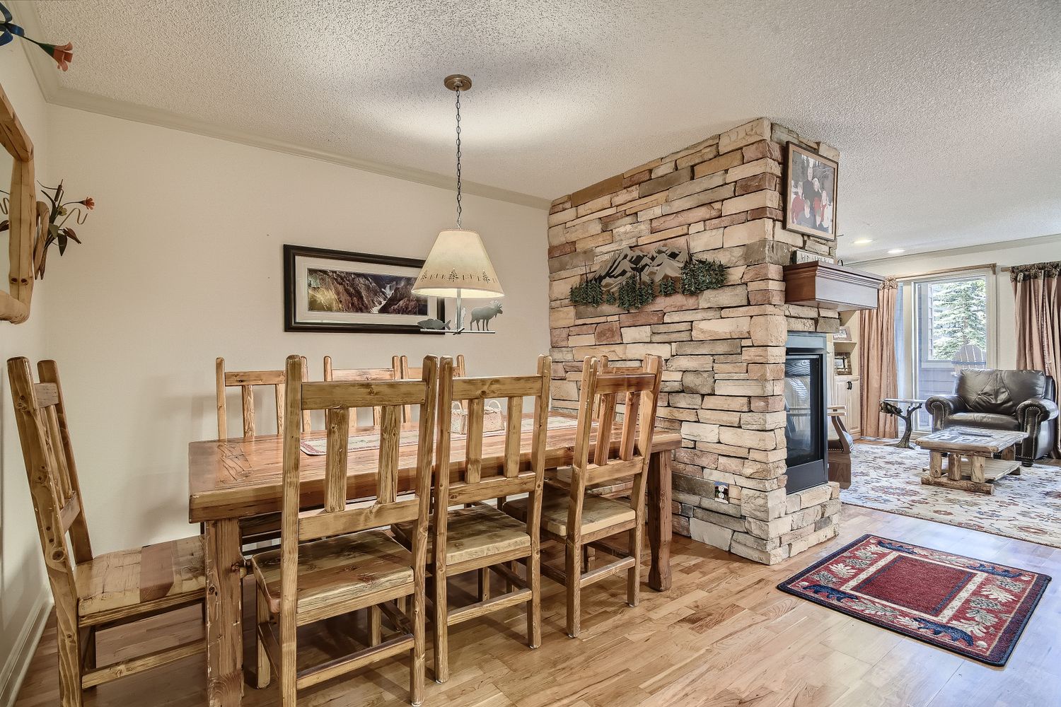 Gather around your rustic dining table for memorable meals by the warm stone fireplace in this cozy mountain retreat.