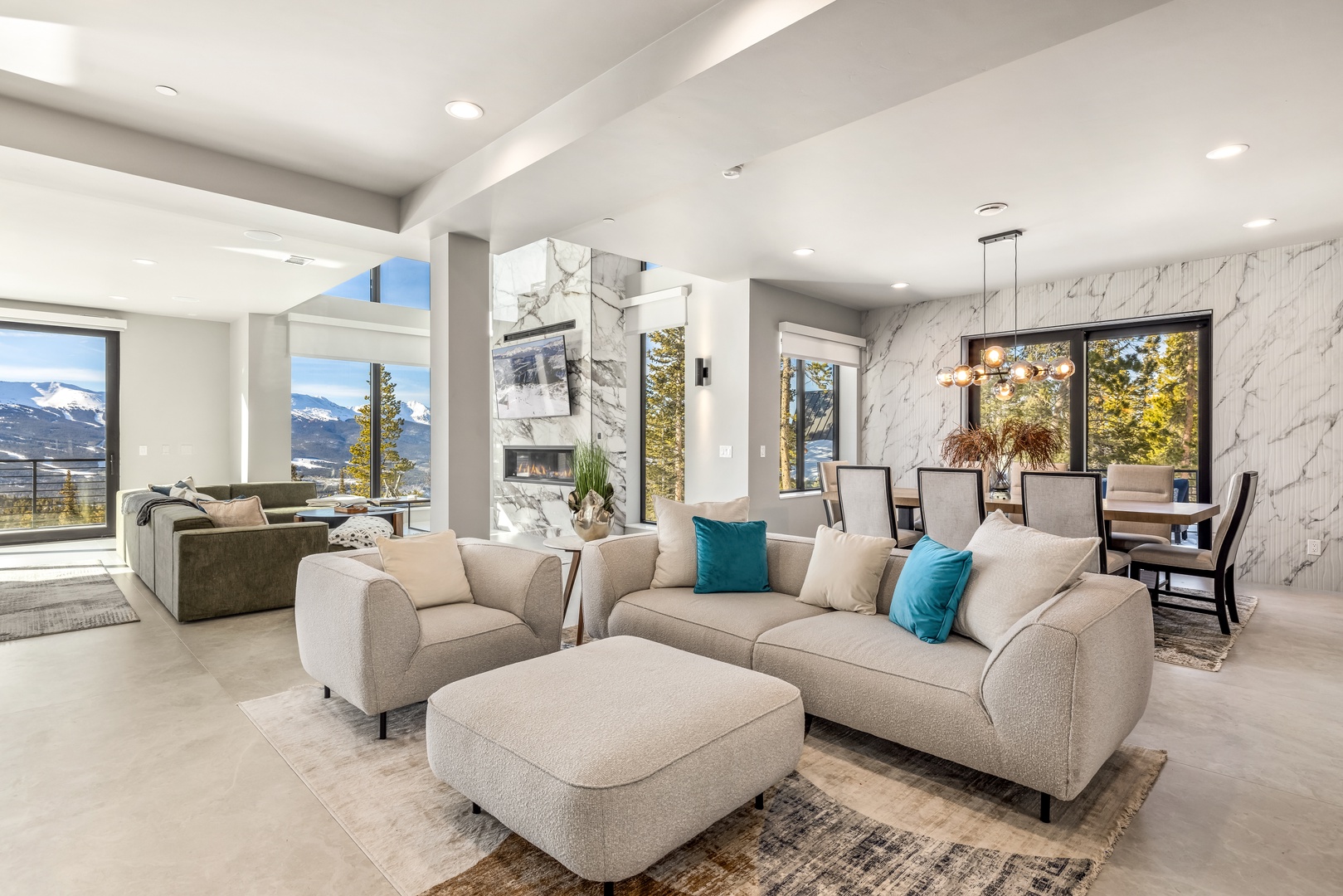 Relax in your contemporary living space with plush seating and stunning mountain views through floor-to-ceiling windows.