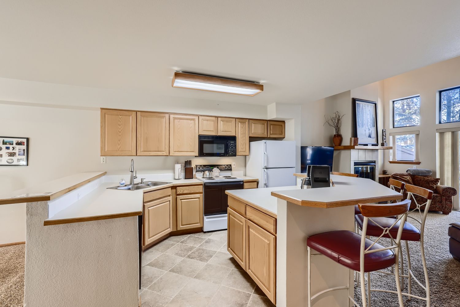 Your spacious kitchen features warm wood cabinetry, full appliances, and a breakfast bar perfect for morning coffee or casual meals.
