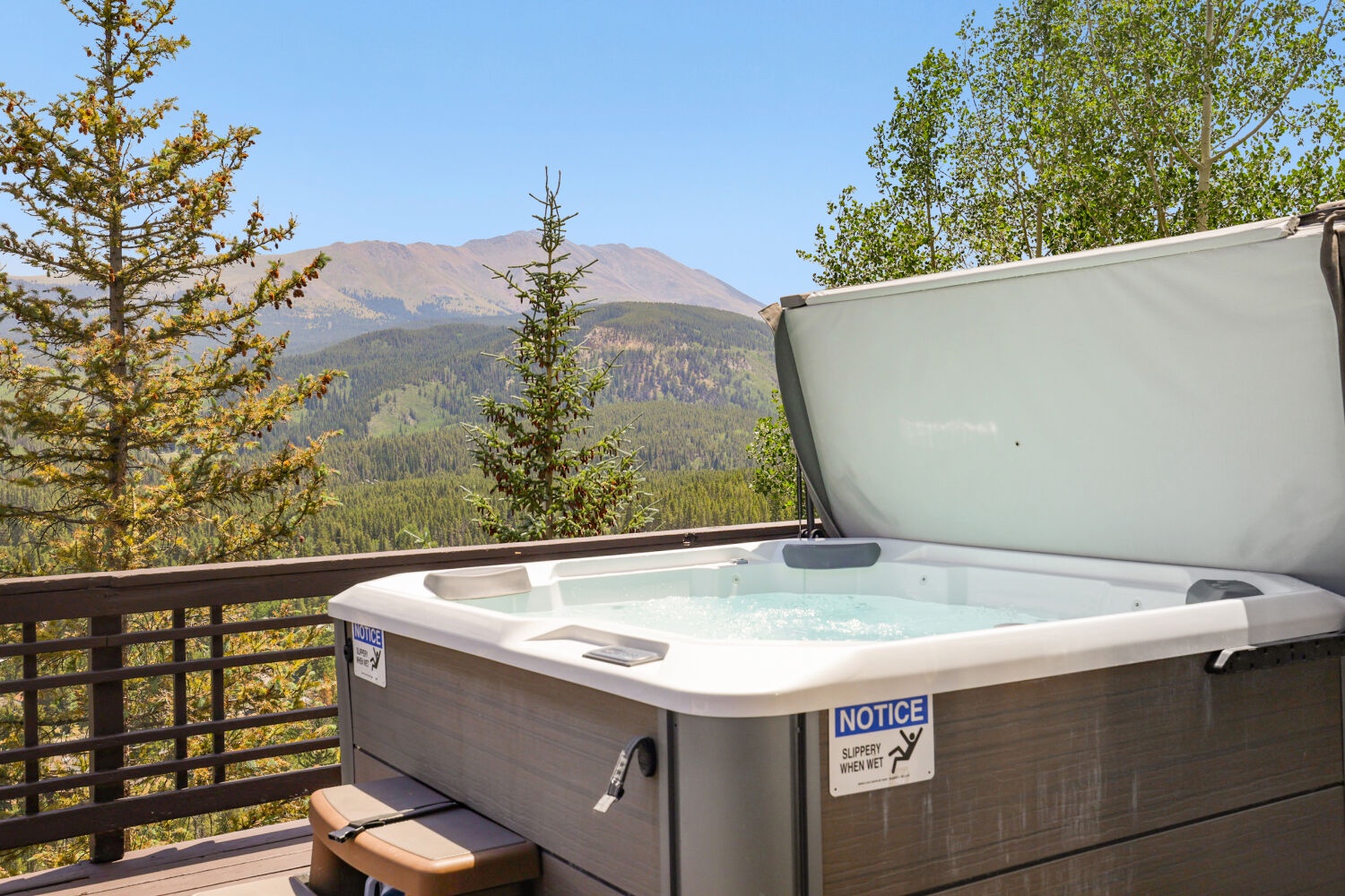 Soak in the hot tub while taking in breathtaking mountain vistas framed by evergreen trees—your perfect alpine escape awaits.