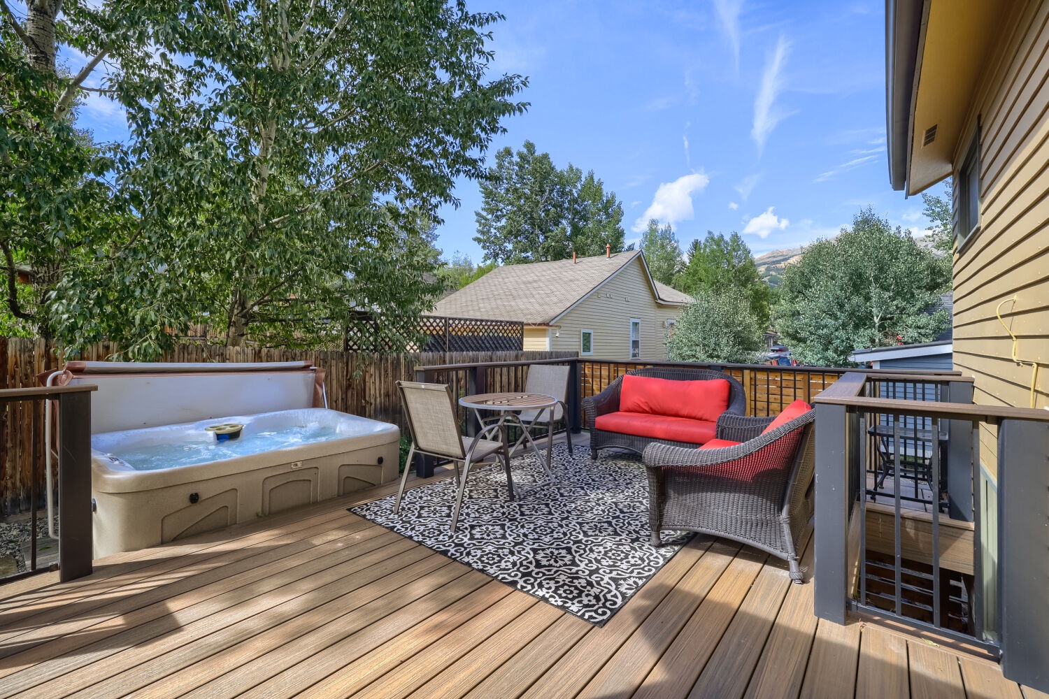 Unwind in your private hot tub on this spacious deck surrounded by trees, with cozy seating perfect for morning coffee or evening relaxation.
