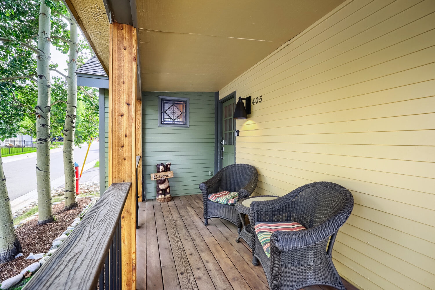Step out to your covered porch with cozy wicker seating—perfect for morning coffee or unwinding in the fresh mountain air surrounded by aspen trees.