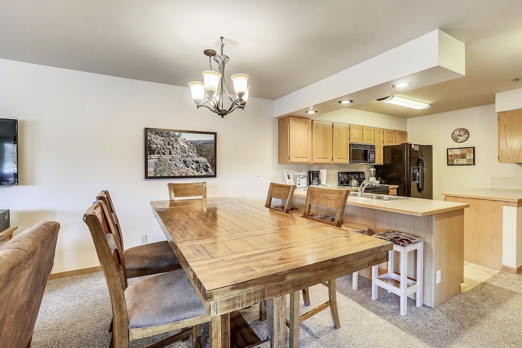 Gather around your rustic wooden dining table where warm conversations flow seamlessly into your fully-equipped kitchen.