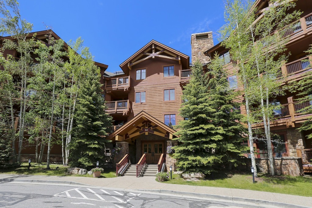 Mountain lodge complex surrounded by towering aspen trees and pristine natural beauty.