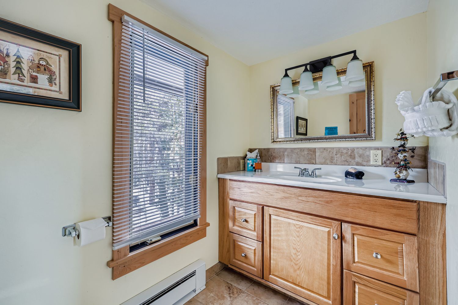 Freshen up in this bright bathroom featuring warm wood vanity, spacious counter, and natural light streaming through your private window.